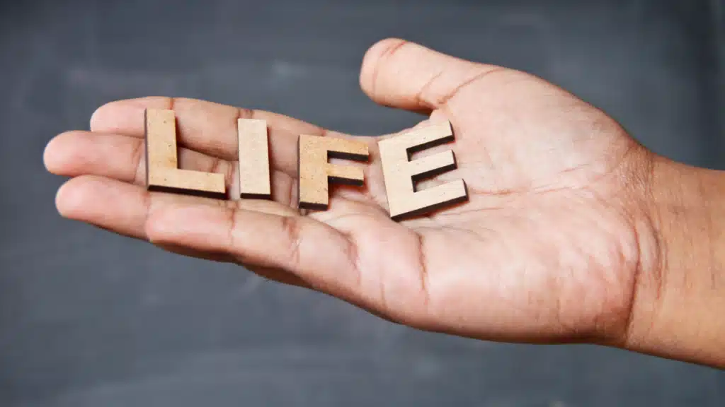 Hand hält das Wort Life als Symbol für Neuanfang im Leben und Midlife-Crisis bei Männern