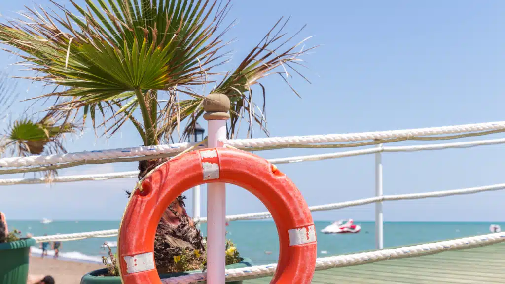 Rettungsring am Strand als Symbol für Sicherheit und Neuanfang im Leben während der Midlife-Crisis bei Männern